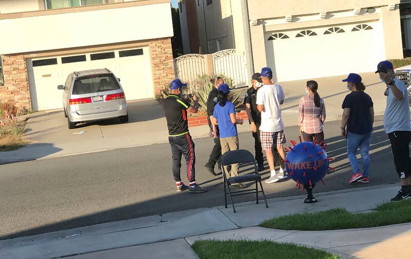 Chinese protesters shout slogans and display a Covid-19 virus inflatable outside Wu Jianmin's home in Irvine, Calif., in 2020. American officials say foreign countries like Iran and China intimidate, harass and sometimes plot violence against political opponents and activists in the U.S. For Jianmin, The harassment lasted more than two months. (Wu Jianmin via AP)