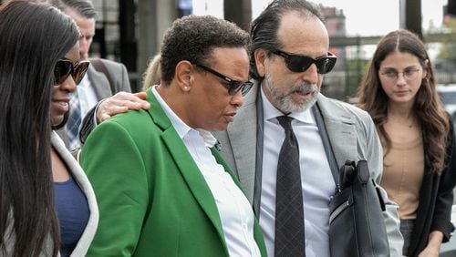 Rev Mitzi Bickers (green blazer) is found guilty on all but three charges at the Richard B Russell Federal Courthouse on Wednesday, March 23, 2022.  Bickers is surrounded by friends, family and her attorney Drew Findling (dark sunglasses) as she leaves the courthouse.  Sentencing is scheduled for July 12.  (Jenni Girtman for The Atlanta Journal-Constitution) 