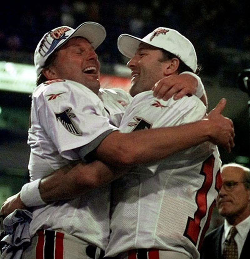 Falcons' Morten Andersen (left) and Chris Chandler celebrate on the podium after the Falcons beat the Minnesota Vikings 30-27 to win the NFC Championship on Sunday, Jan. 17, 1999, in Minneapolis. (John Bazemore/AP)