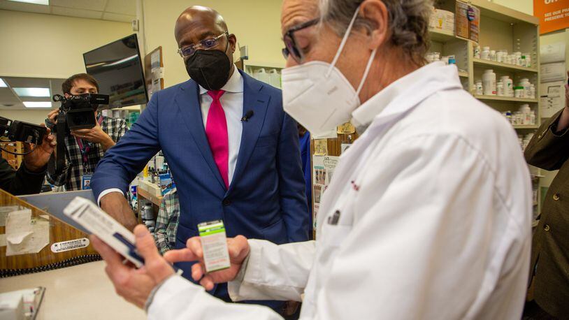 U.S. Sen. Raphael Warnock talks with pharmacist Ira Katz about his proposal to cap the price of insulin during a visit last month to the Little Five Points Pharmacy. STEVE SCHAEFER FOR THE ATLANTA JOURNAL-CONSTITUTION