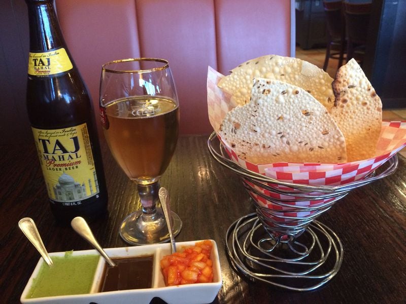 Dinner at Pinch of Spice begins with a basket of papadum and a trio of mint, tamarind and onion chutneys. They’re shown here with a Taj Mahal beer. CONTRIBUTED BY WENDELL BROCK
