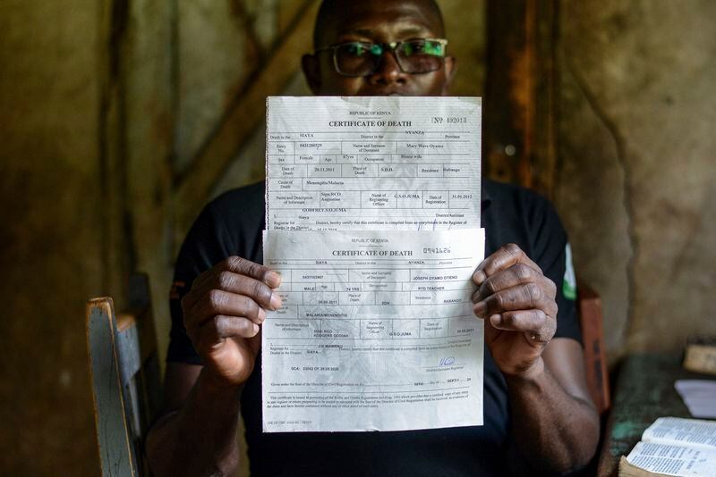 Humphrey Kizito holds death certificates of his parents who died of Malaria at their home in Siaya, Kenya Saturday, April. 13, 2024. Even after parts of Kenya participated in an important pilot of the world's first malaria vaccine, with a reported drop in deaths for children under 5, the disease is still a significant public health challenge. Kenya's health ministry hasn't said when the vaccine will be widely available. (AP Photo/Brian Ongoro)