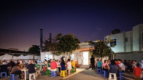 Guests dine at plastic picnic tables in front of Bu Qtair, everyone’s favorite Indian fish fry. (Dubai Tourism)