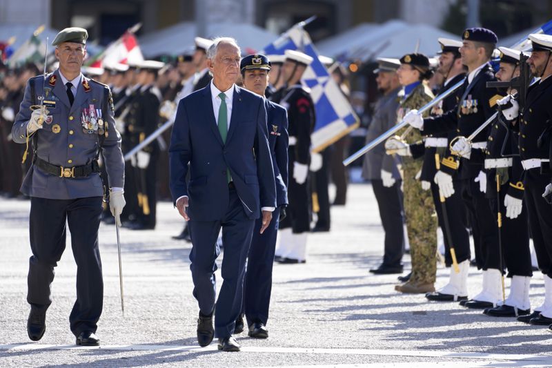Portuguese President Marcelo Rebelo de Sousa, front, reviews troops before a military parade at Lisbon's Comercio square, Thursday, April 25, 2024, during celebrations of the fiftieth anniversary of the Carnation Revolution. The April 25, 1974 revolution carried out by the army restored democracy in Portugal after 48 years of a fascist dictatorship. (AP Photo/Armando Franca)