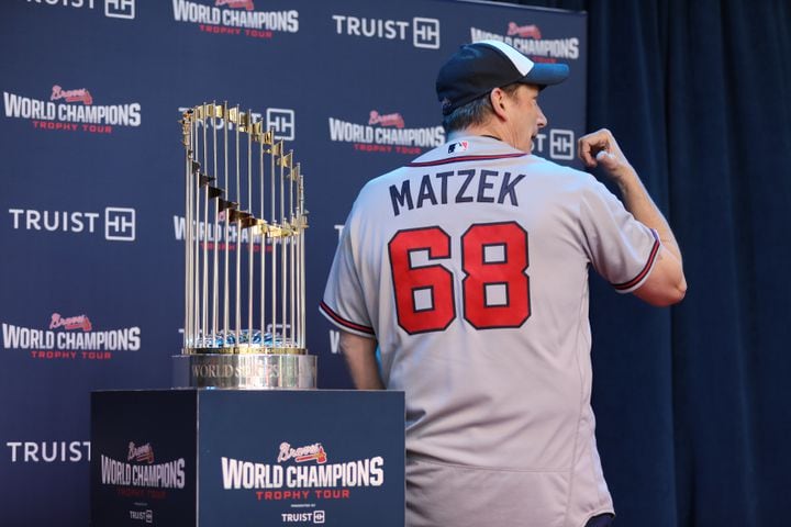 Roy Norman from Atlanta poses beside the 2021 World Champions Trophy while wearing a Tayler Matzek jersey. Miguel Martinez for The Atlanta Journal-Constitution 