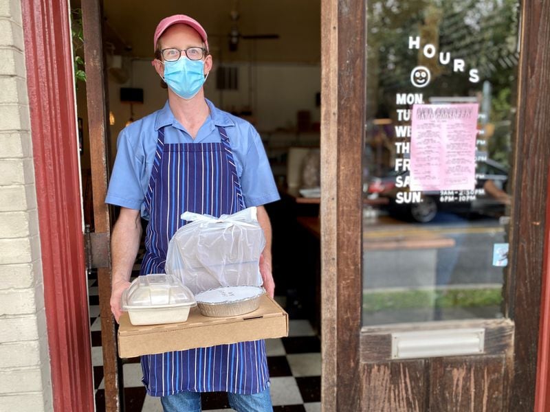 Gato chef-owner Nicholas Stinson brings a takeout order out the door of his Candler Park diner. Wendell Brock for The Atlanta Journal-Constitution