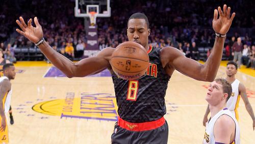 Atlanta Hawks center Dwight Howard, center, dunks as Los Angeles Lakers center Timofey Mozgov, lower right, of Russia, and Los Angeles Lakers guard Nick Young, upper right, watch during the first half of an NBA basketball game, Sunday, Nov. 27, 2016, in Los Angeles. (AP Photo/Mark J. Terrill)