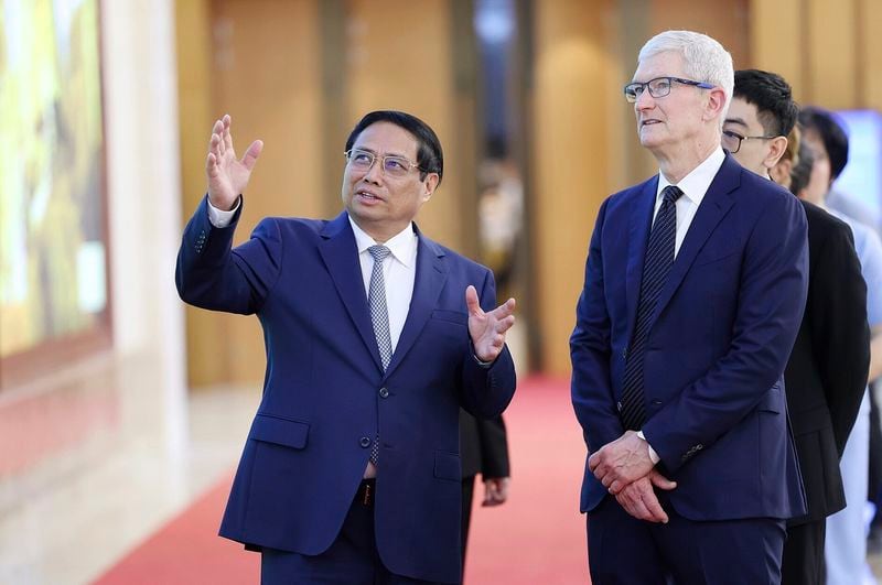Vietnamese Prime Minister Pham Minh Chinh, left, speaks to Apple CEO Tim Cook, right, before their meeting in Hanoi, Vietnam on Tuesday, April 16, 2024. The tech giant CEO is on a visit to Vietnam to promote cooperation and boost investment in the Southeast Asian nation. (Duong Van Giang/VNA via AP)