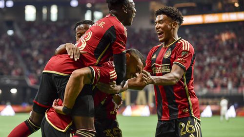 Atlanta United midfielder Derrick Etienne (18) and defender Caleb Wiley (26) celebrate after forward Giorgos Giakoumakis (7) scores against D.C. United during the first half of an MLS match Saturday, June 10, 2023 at Mercedes Benz Stadium.  (Daniel Varnado/ For the AJC)