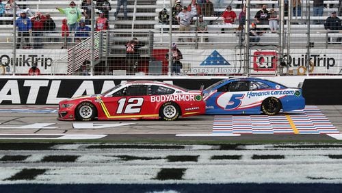 Ryan Blaney in the No. 12 car passes Kyle Larson with eight laps remaining on his way to winning the Atlanta Motor Speedway Folds of Honor QuickTrip 500 on Sunday, March 21, 2021, in Hampton, Georgia. (Curtis Compton/Atlanta Journal-Constitution/TNS)
