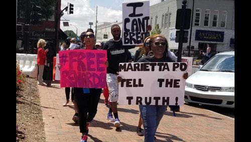 Lubreeze Lewis, right, marches in a protest held Friday in downtown Marietta against the treatment of her husband, Renardo Lewis.