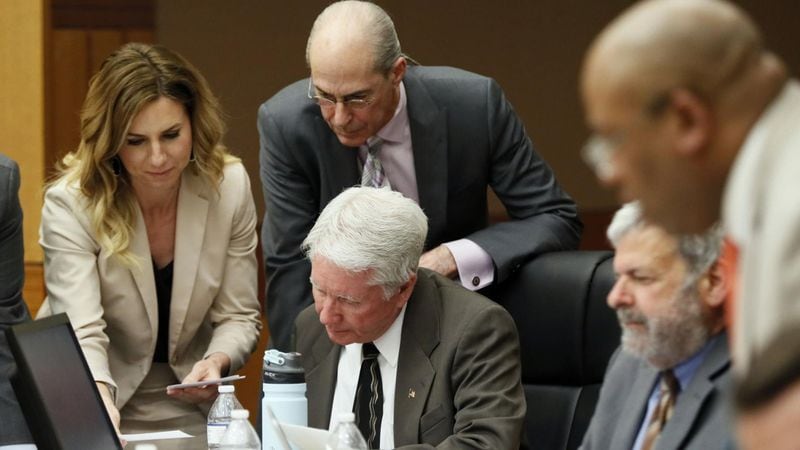 Tex McIver (seated in the center) is surrounded by attorneys (from left, Amanda Clark Palmer, Bruce Harvey and Don Samuel) as they review questions from the jury during testimony in the Tex McIver murder trial. Lead prosecutor Clint Rucker is in the foreground on the right. Bob Andres bandres@ajc.com