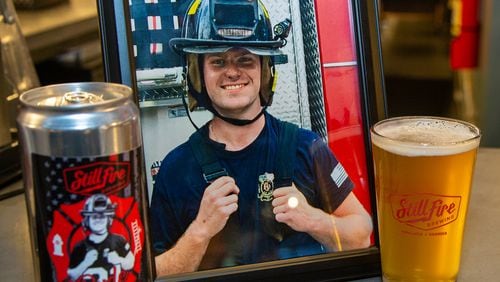 A photo of Chandler Patterson, who tragically died last summer, sat on the bar with the new Dude21 special brew in his honor. Family, friends & fellow firefighters gathered at Stillfire Brewing in Suwanee to honor Patterson with the launch on the new brew. His widow, Alyssa Patterson, reached out to the brewery, which was often she & the Gainesville firefighter's date night place, to see what they could do. She was able to help create the special brew with the brewmaster & friends. PHIL SKINNER FOR THE ATLANTA JOURNAL-CONSTITUTION.
