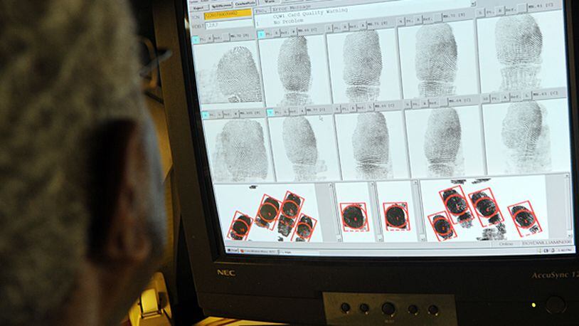 Fingerprint technician William Boyd inspects fingerprints and potential fingerprint matches at the Georgia Crime Information Center, a division of the Georgia Bureau of Investigations, in Decatur Monday, Aug. 15, 2011. The system is usually automated, but it will flag certain prints with anomalies so they can be looked at with a human eye. More employers, both private and public, are using background checks to screen potential job candidates.