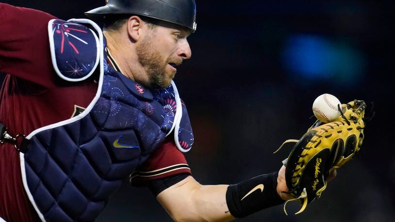 Arizona Diamondbacks catcher Stephen Vogt tries to make the catch on a foul ball hit by San Francisco Giants' Steven Duggar during the eighth inning of a baseball game Friday, July 2, 2021, in Phoenix. (AP Photo/Ross D. Franklin)