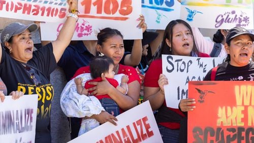 Immigrant rights activists protest HB 1105, which would would mandate that local law enforcement work more closely with ICE, at Liberty Plaza in front of the Capitol in Atlanta on Wednesday, May 1, 2024. (Arvin Temkar / AJC)