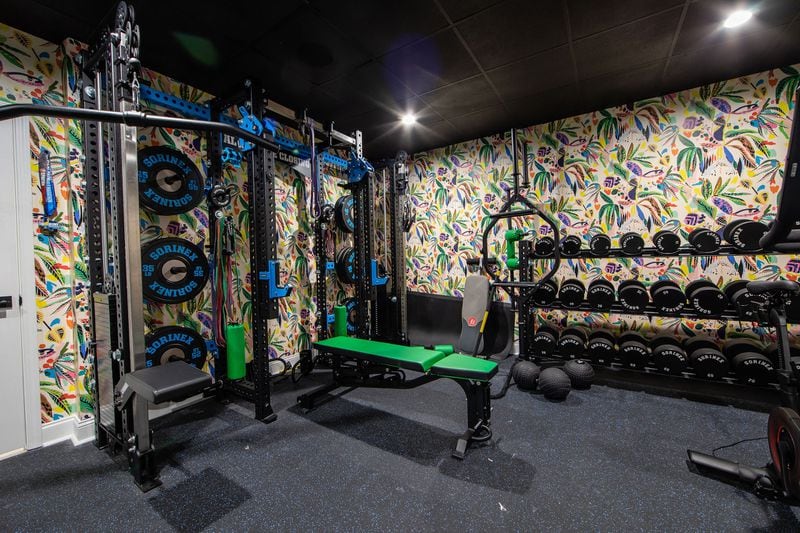 Josh and Rachel Nelson call this their “jungle gym” because of the splashy wallpaper from Milton + King that interior designer Gabriela Eisenhart chose to fit a retro 80s vibe. Sorinex, a company which offers customized workout equipment, supplied the weights and benches that Josh selected in vibrant greens and blues to complement the walls. Text by Lori Keong/Photo by Amanda Winchester