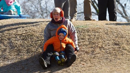 Rachel Blacher and her son Calder McCwan slide down a frozen grass hill at Candler Park Golf Course Saturday, January 7, 2016. in Atlanta Ga. freezing temperatures are expected to continue through Sunday.  STEVE SCHAEFER / SPECIAL TO THE AJC