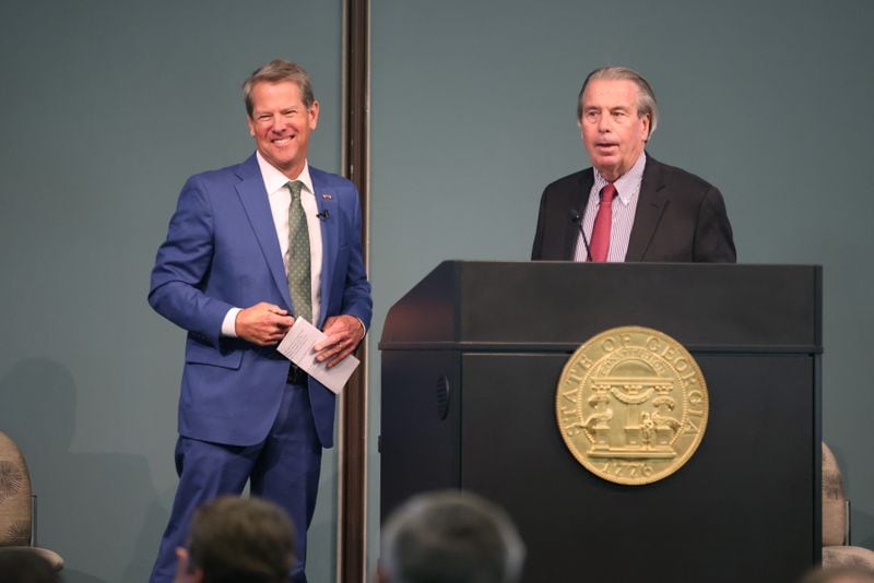 Gov. Brian Kemp, left, reacts with Dennis Shea, of Area Development magazine, which named Georgia top state for doing business in 2022 at at the Kia Plant on Sept. 28, 2022, in West Point, Georgia. (Jason Getz / AJC)