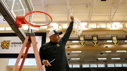 Kennesaw State coach Amir Abdur-Rahim reacts to the fans as he holds the net after winning the ASUN Tournament on Sunday. (Miguel Martinez / miguel.martinezjimenez@ajc.com)