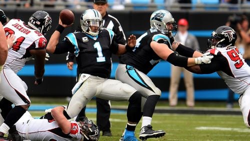 Carolina Panthers quarterback Cam Newton (1) fights to get off a pass as Atlanta Falcons defensive end Brooks Reid, bottom, wraps up Newton’s right leg in the third quarter on Saturday, Dec. 24, 2016, at Bank of America Stadium in Charlotte, N.C. The Falcons won, 33-16. (Jeff Siner/Charlotte Observer/TNS)