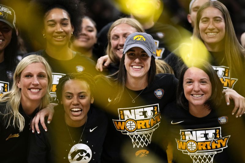 Iowa guard Caitlin Clark, center, poses for a photos with teammates and coaches during an Iowa women's basketball team celebration Wednesday, April 10, 2024, in Iowa City, Iowa. Iowa lost to South Carolina in the college basketball championship game of the women's NCAA Tournament on Sunday. (AP Photo/Charlie Neibergall)