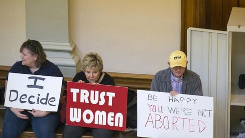 Demonstrators on both sides of the issue of abortion sit in the lobby with their signs as members of the Georgia Senate debate House Bill 481, the anti-abortion “heartbeat” bill. (ALYSSA POINTER/ALYSSA.POINTER@AJC.COM)