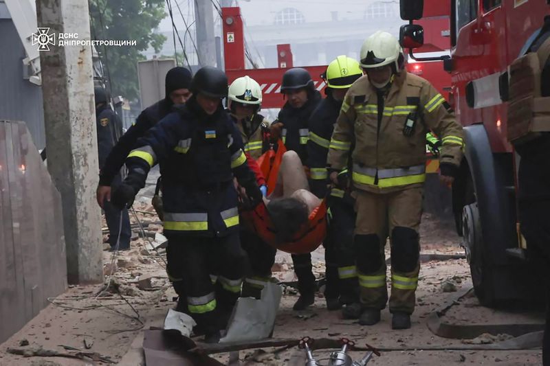 In this photo provided by the Ukrainian Emergency Service, rescuers and ambulance workers carry a person on the scene of a Russian attack in Dnipro, Ukraine, Friday, April 19, 2024. (Ukrainian Emergency Service via AP Photo)