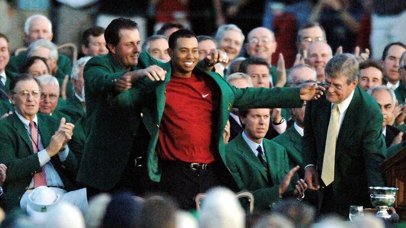 Phil Mickelson puts the green jacket on Tiger Woods as he claims his fourth Masters championship Sunday, April 10, 2005, at Augusta National Golf Club.