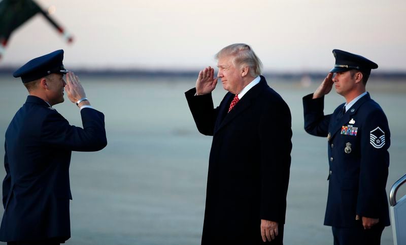 President Donald Trump salutes as he stands on the tarmac after disembarking Air Force One as he arrives Sunday, March 5, 2017, at Andrews Air Force Base, Md. Trump is returning from Mar-a-Largo, Fla. (AP Photo/Alex Brandon)