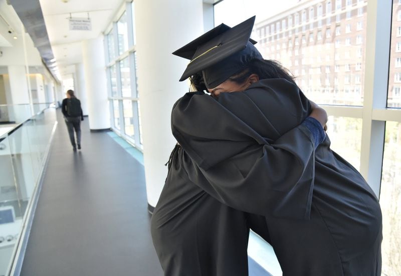 Carrie Crayton and Natalie Jackson (right), both first graduating class of EXCEL program for students with mild intellectual and developmental disabilities, embrace after they try on their caps and gowns at Georgia Tech’s Scheller College of Business. 