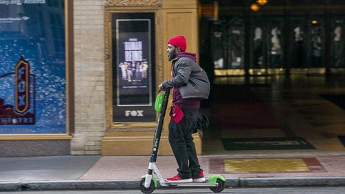 A man rides a Lime Scooter along Peachtree Street in Atlanta’s Midtown community, Friday, Jan. 4, 2019.
