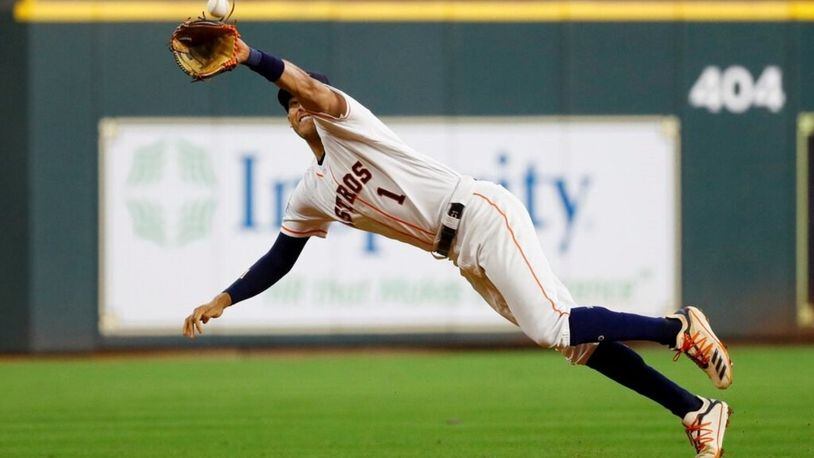 Houston Astros shortstop Carlos Correa catches a line drive by Washington Nationals' Howie Kendrick during the fourth inning of Game 1 of the baseball World Series Tuesday, Oct. 22, 2019, in Houston.