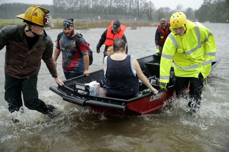 Rescue workers from Township No. 7 Fire Department and volunteers from the Civilian Crisis Response Team use a boat to rescue a woman and her dog from their flooded home during Hurricane Florence September 14, 2018 in James City, North Carolina. 