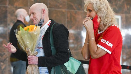 Deb Halleck (right) smiles after meeting partner Stephen Donnelly after he arrives from the UK Monday at Hartsfield-Jackson Atlanta International Airport. (Daniel Varnado/ For The Atlanta Journal-Constitution)