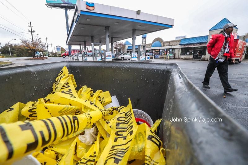 Discarded crime scene tape sits at a Chevron station on the corner of Pryor Road and University Avenue in southwest Atlanta where three people were shot on Nov. 14. (Photo: JOHN SPINK / JSPINK@AJC.COM)