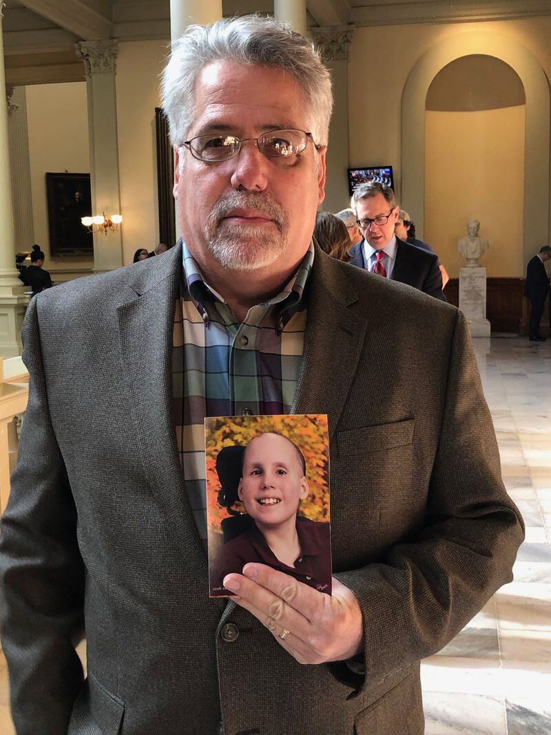 Woodstock resident David Fige holds a photo of his daughter, 15-year-old Katelyn, a cancer survivor, at the state capitol on Crossover Day. Fige came to advocate for a bill designating Childhood Cancer Awareness Day, which he said is being held up by House Speaker David Ralston to punish one of his critics. CHRIS JOYNER / CJOYNER@AJC.COM