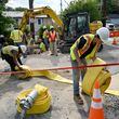 Workers move equipment in place as they worked to fix a water main break at Joseph E. Boone Boulevard on Saturday.
