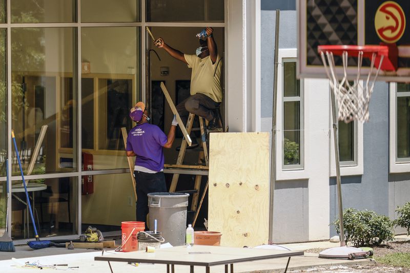 Workers repair a broken window at At-Promise Youth Center on Friday, May 27 2022. (Natrice Miller / natrice.miller@ajc.com)