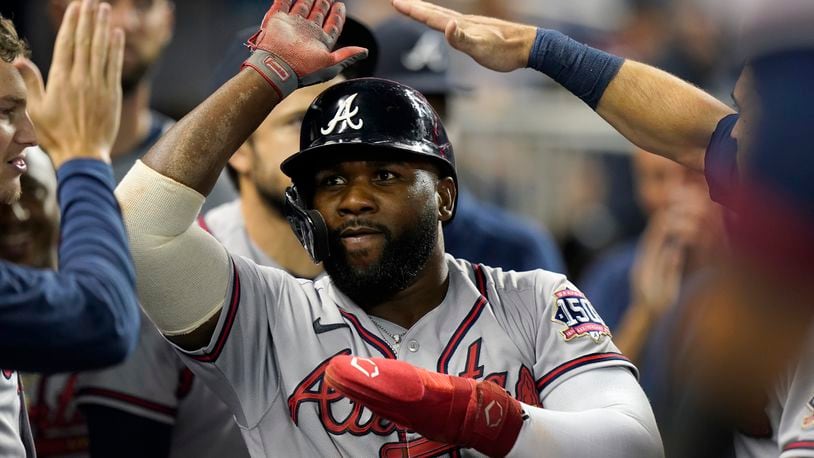 Atlanta Braves' Abraham Almonte celebrates with teammates after he scored on a single by Jorge Soler during the eighth inning of a baseball game against the Miami Marlins, Tuesday, Aug. 17, 2021, in Miami. (AP Photo/Wilfredo Lee)