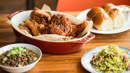 Mary Hoopa’s whole fried chicken, half spicy, half sweet, with sides of rolls, Sea Island red peas, and Brussels sprouts. CONTRIBUTED BY MIA YAKEL