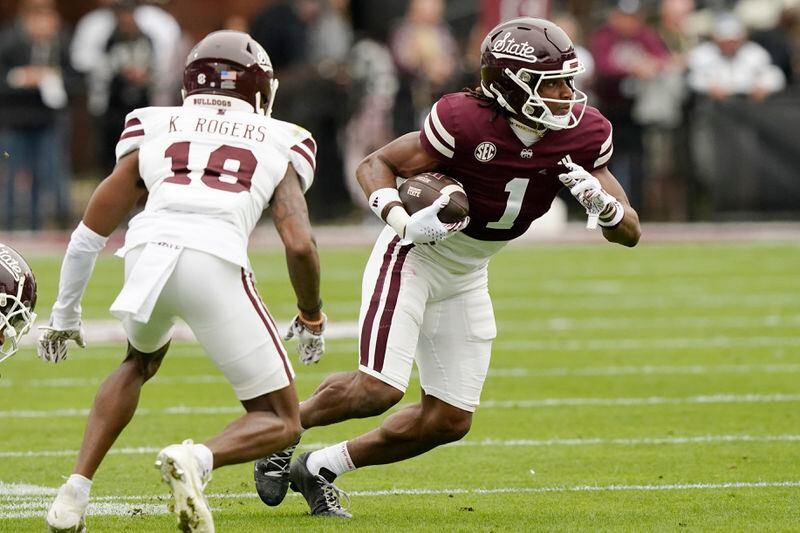 Maroon Team wide receiver Kelly Akharaiyi (1) evades a tackle attempt by White Team cornerback Khamauri Rogers (18) during Mississippi State's NCAA college spring football game, Saturday, April 20, 2024, in Starkville, Miss. (AP Photo/Rogelio V. Solis)