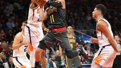 Hawks guard Trae Young goes to the basket through a triple team and draws a foul during a 123-110 victory over the Phoenix Suns in a NBA basketball game on Tuesday, January 14, 2020, in Atlanta.    Curtis Compton ccompton@ajc.com