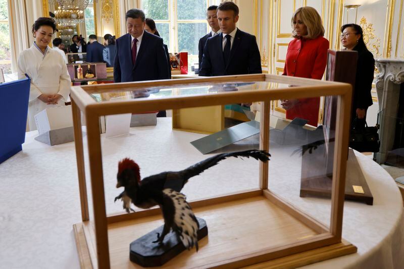 Chinese President Xi Jinping, second left, presents to French President Emmanuel Macron gifts laid out on the table, as their wives China's Peng Liyuan, left, and the French President's wife Brigitte Macron look on during a gifts exchange at the Elysee Palace in Paris, Monday, May 6, 2024. China's President Xi Jinping is in France for a two-day state visit that is expected to focus both on trade disputes and diplomatic efforts to convince Beijing to use its influence to move Russia toward ending the war in Ukraine. (Ludovic Marin, Pool via AP)