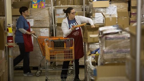 A volunteer gathers gifts in the warehouse for shoppers at Santa’s Village, which distributes toys through the nonprofit Empty Stocking Fund. (Photo by Phil Skinner)