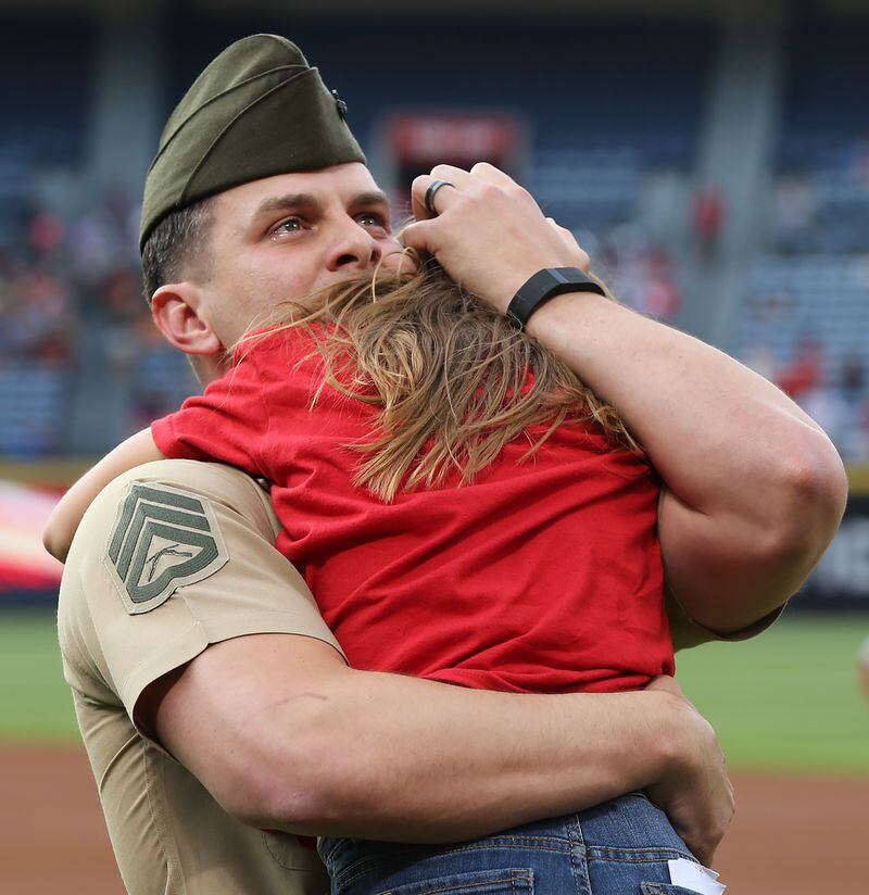 051116 ATLANTA: U.S. Marine Corps SSG Clayton Walker is moved to tears as he is reunited with his daughter Cassidy, 10, Langston Elementary School, Perry, GA, after his fifth tour of duty just before the first pitch in the Braves and Phillies baseball game at Turner Field on Wednesday, May 11, 2016, in Atlanta. Curtis Compton / ccompton@ajc.com
