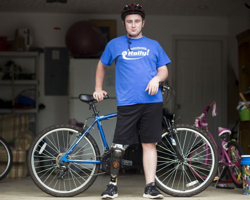 Matthew McMahon proudly poses next to his triathlon bike in front of his Woodstock home recently. In 2014, Matthew McMahon was diagnosed with bone cancer. This not only required intensive treatment, but also the amputation of his right leg from the knee down. However, McMahon, who wears a prosthesis, didn’t give up being an athlete. CHAD RHYM / CHAD.RHYM@AJC.COM