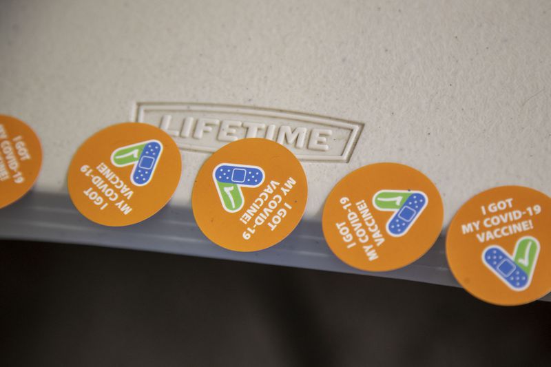 Celebratory stickers are available to patients that receive a dose of the COVID-19 vaccine during a drive thru at Jim Miller Park in Marietta. (Alyssa Pointer / Alyssa.Pointer@ajc.com)