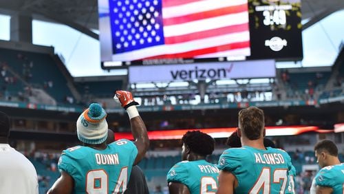 Miami Dolphins defensive end Robert Quinn (94) raises his fist during the national anthem prior to the game against the Tampa Bay Buccaneers at Hard Rock Stadium.