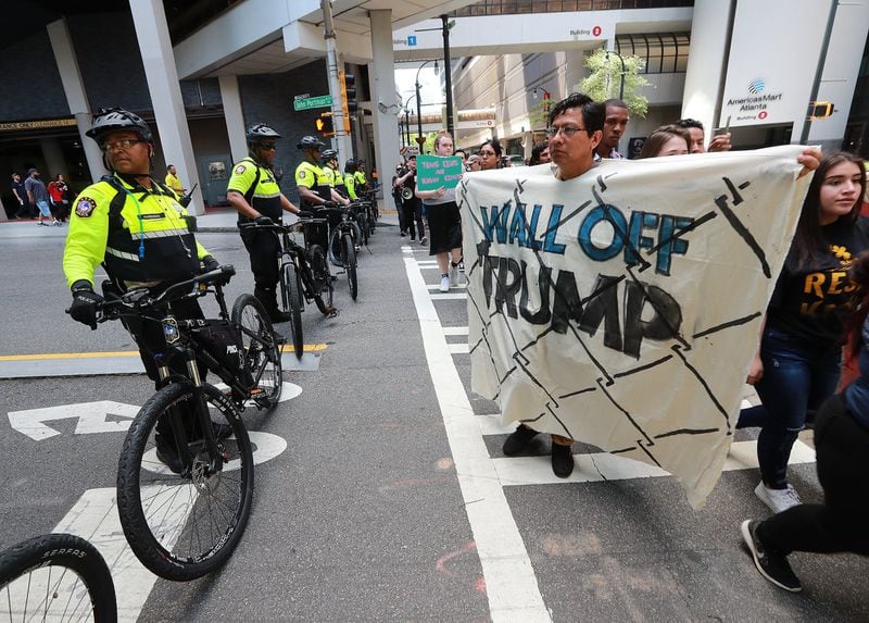 A bicycle response team blocks off John Portman Boulevard from marchers on their way to Hardy Ivy Park to protest President Donald Trump while he headlined a summit targeting prescription drug abuse on Wednesday in Atlanta. Curtis Compton/ccompton@ajc.com